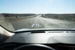 Daytime windshield head-up display showing 72 MPH and a navigation arrow on a highway