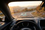 Head-up display projecting speed on a scenic mountain highway at golden hour